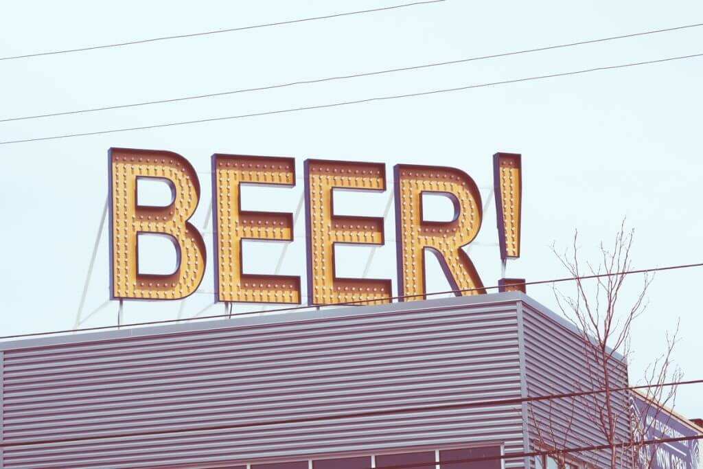 A sign on top of a building saying: BEER! This, like using near me SEO, is one of many ways to attract business in the local area.
